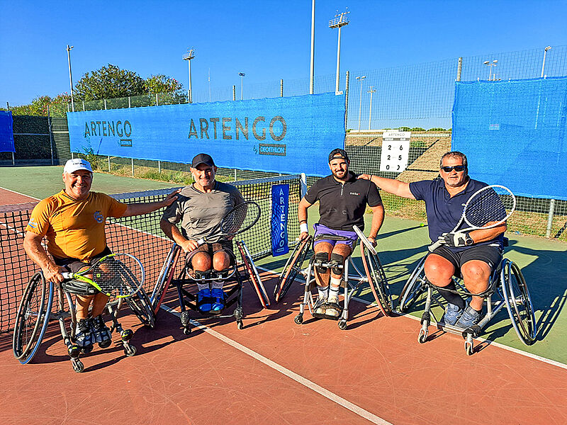 4 joueurs de tennis fauteuil dont Guilhem Laget au centre droit posent devant sur le court.